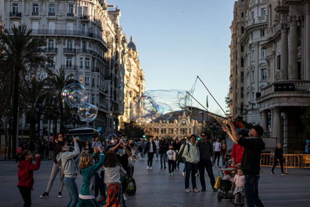 a crowd of people walking down a street next to tall buildings