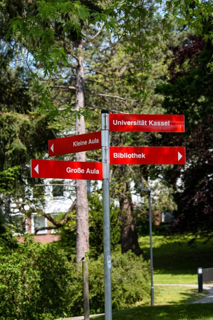 A red street sign sitting on the side of a road